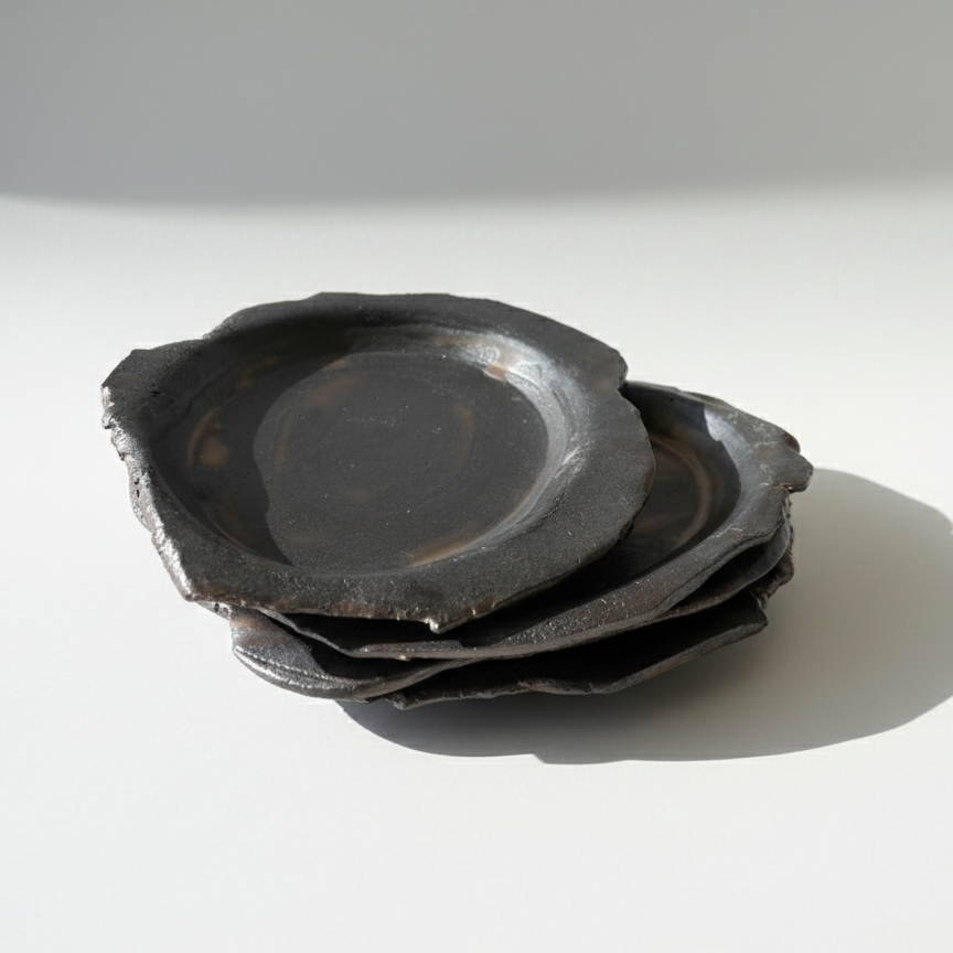 Stack of black ceramic plates on a white background